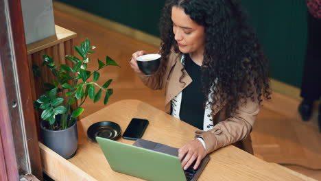 laptop, cafe tea cup and woman typing