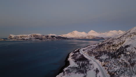 carretera escénica a lo largo del fiordo y el paisaje montañoso nevado en escandinavia