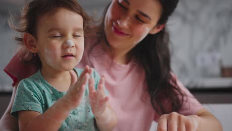 A Heartwarming Moment Between Mother and Child: Joyful Playtime with Flour and Laughter in a Cozy Kitchen Setting