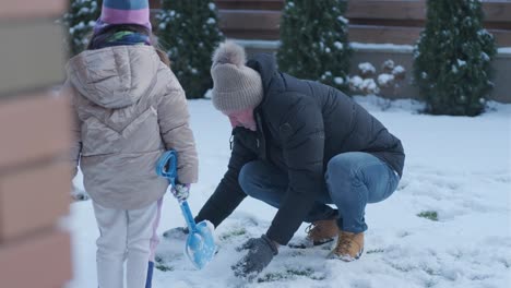 grandfather and granddaughter having fun in the snow