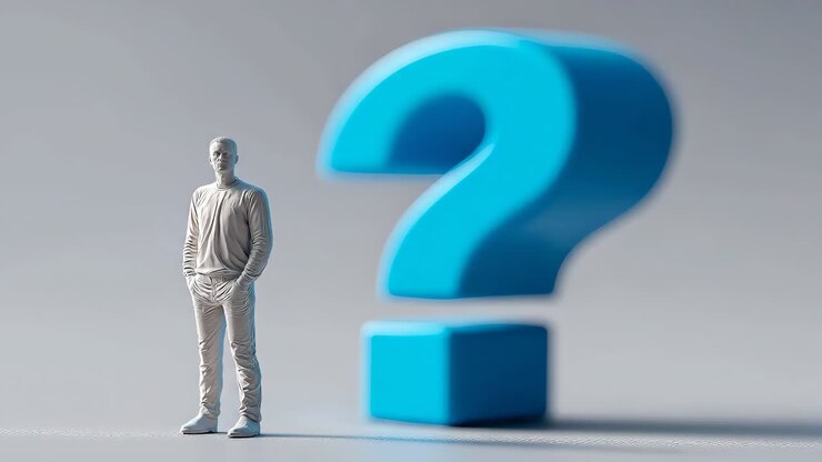 white figurine of man standing near large blue question mark