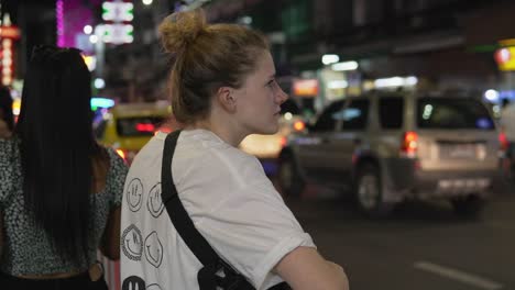 camera focusing on a female traveler exploring bangkok chinatown's busy nightlife