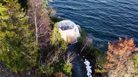 arctic dome on the cliff surrounded with trees and water