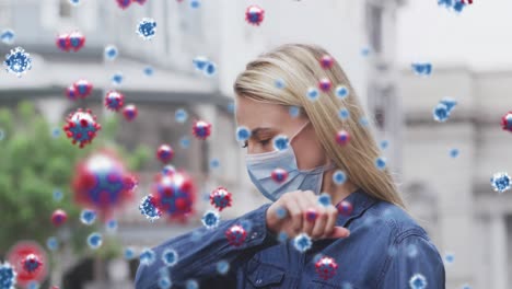 Animation-of-virus-cells-over-caucasian-female-wearing-face-mask-coughing