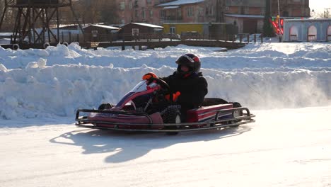 child driving a go-kart on a snowy track