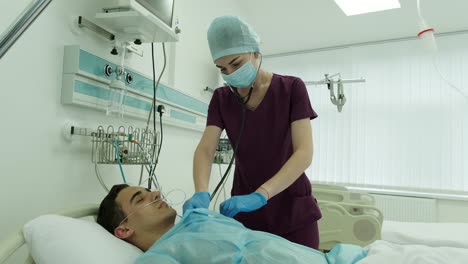 nurse listening to a patients heartbeat in intensive care