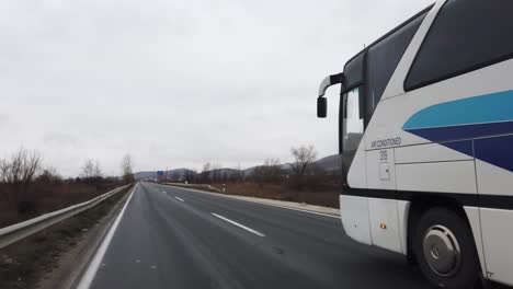 bus on the rural road in autumn, driving on the slippery rainy road