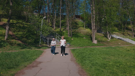 dos mujeres caminando en un parque