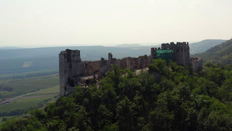 Ruinas-Del-Castillo-De-Piedra-Děvičky-En-La-Cima-De-Una-Colina-En-Moravia,-Disparo-De-Drones