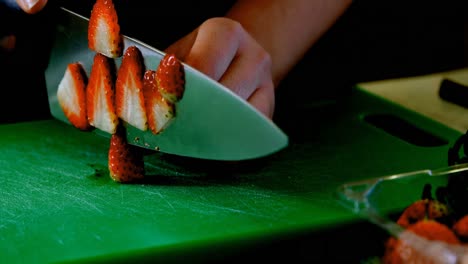 Chef-cutting-strawberry-in-kitchen-4k
