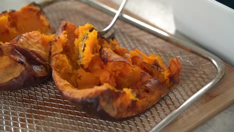 gran primer plano de la calabaza siendo sumergida saliendo del horno asada siendo preparada con ingredientes