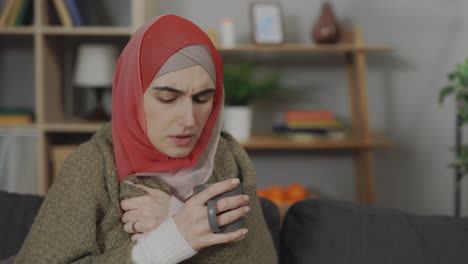 woman drinking warm drink while sick