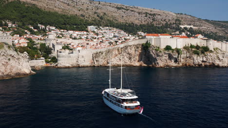 pleasure boat cruising at adriatic sea near walls of dubrovnik in croatia