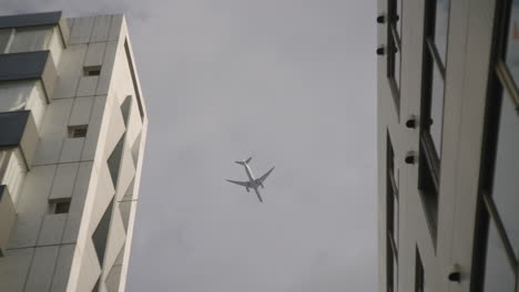 Fliegendes-Flugzeug,-Das-Im-Sommer-In-Tokio,-Japan,-Durch-Die-Skyline-Der-Stadt-Fährt