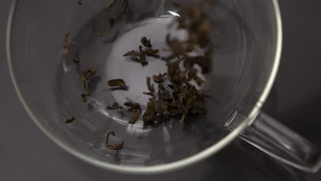 loose tea pouring into glass cup