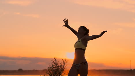 jugador de voleibol femenino del plan medio al atardecer poniendo una espalda en la pelota en cámara lenta.