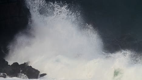 waves crash against a rocky shore in extreme slow motion