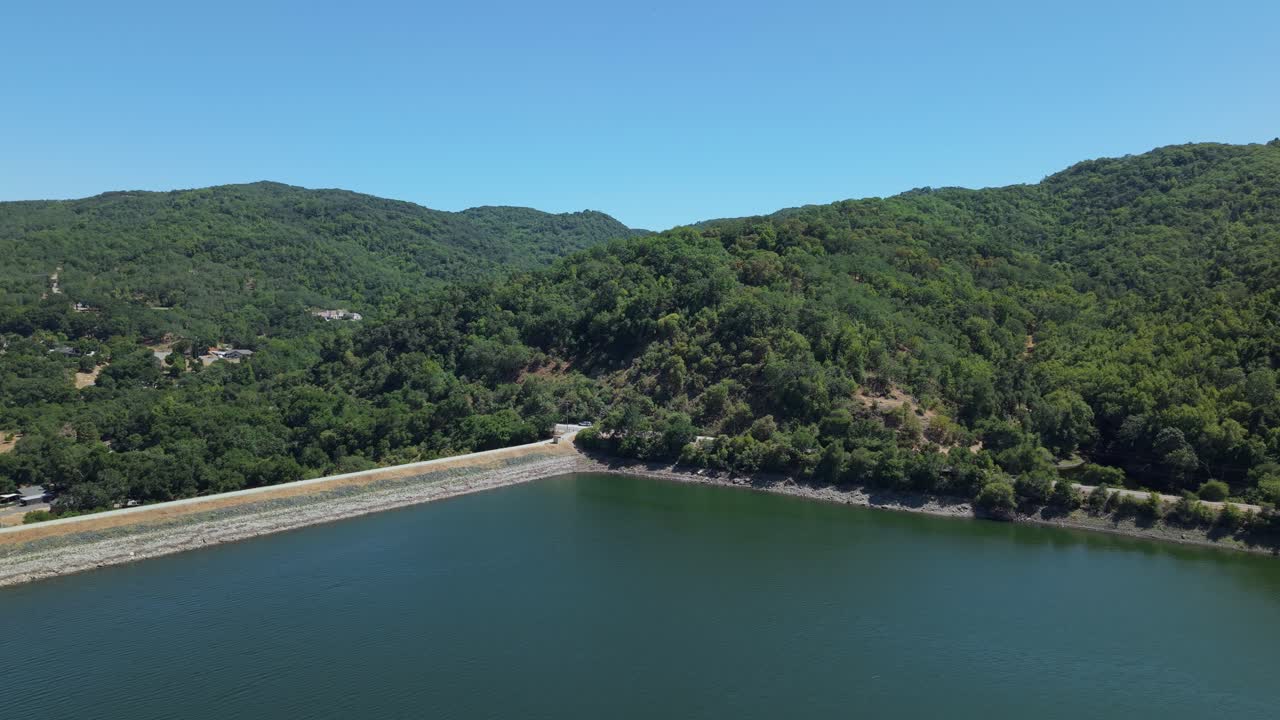 Rolling hills embrace the peaceful expanse of Uvas Reservoir as seen from a sweeping aerial perspective. Filmed in 4K