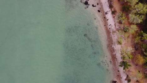 Toma-Aérea-De-Arriba-Hacia-Abajo-De-Una-Costa-Con-Agua-Azul-Verdosa-Y-Arena-Blanca-En-La-Bahía-De-Khao-Ta-Mong-Lai