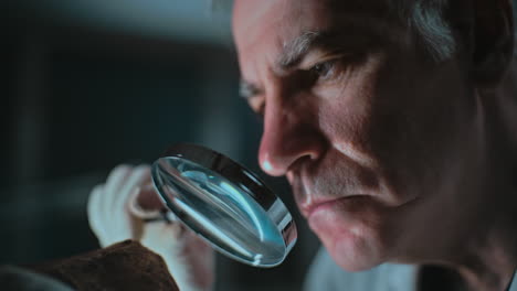 scientist examining artifact with magnifying glass