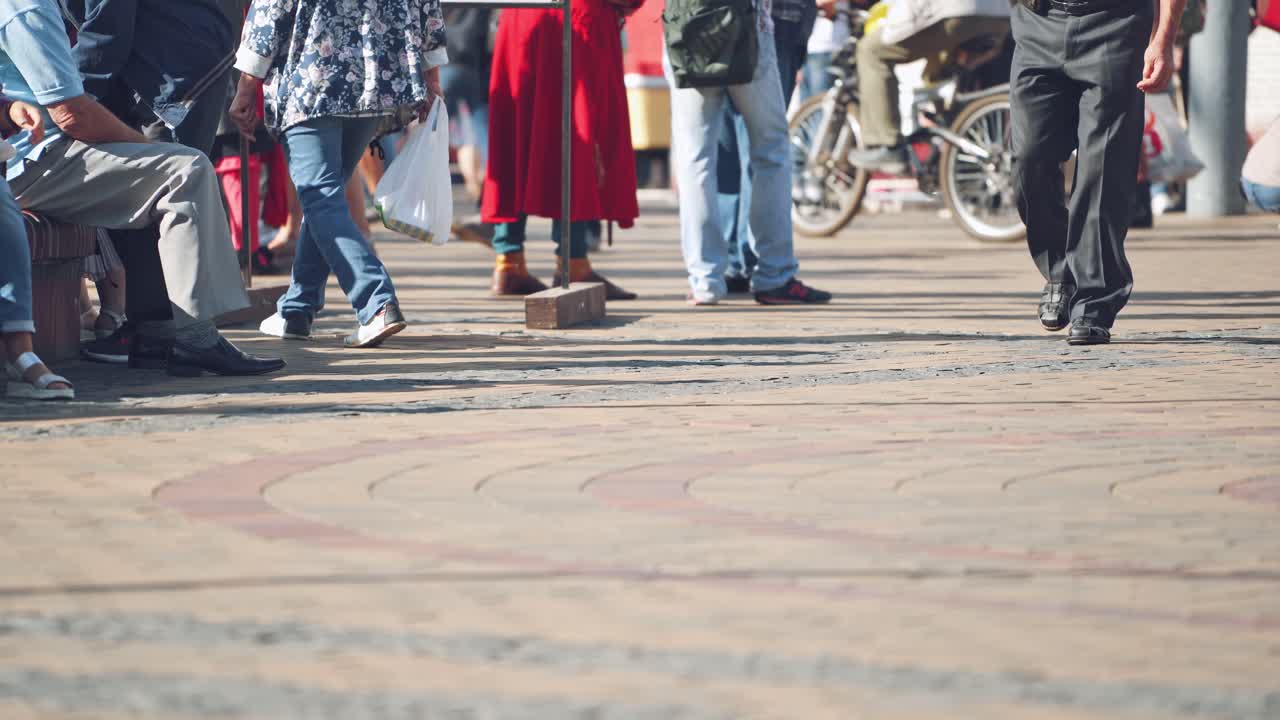 Feet of walking people in city. Low down shot of people walking on street