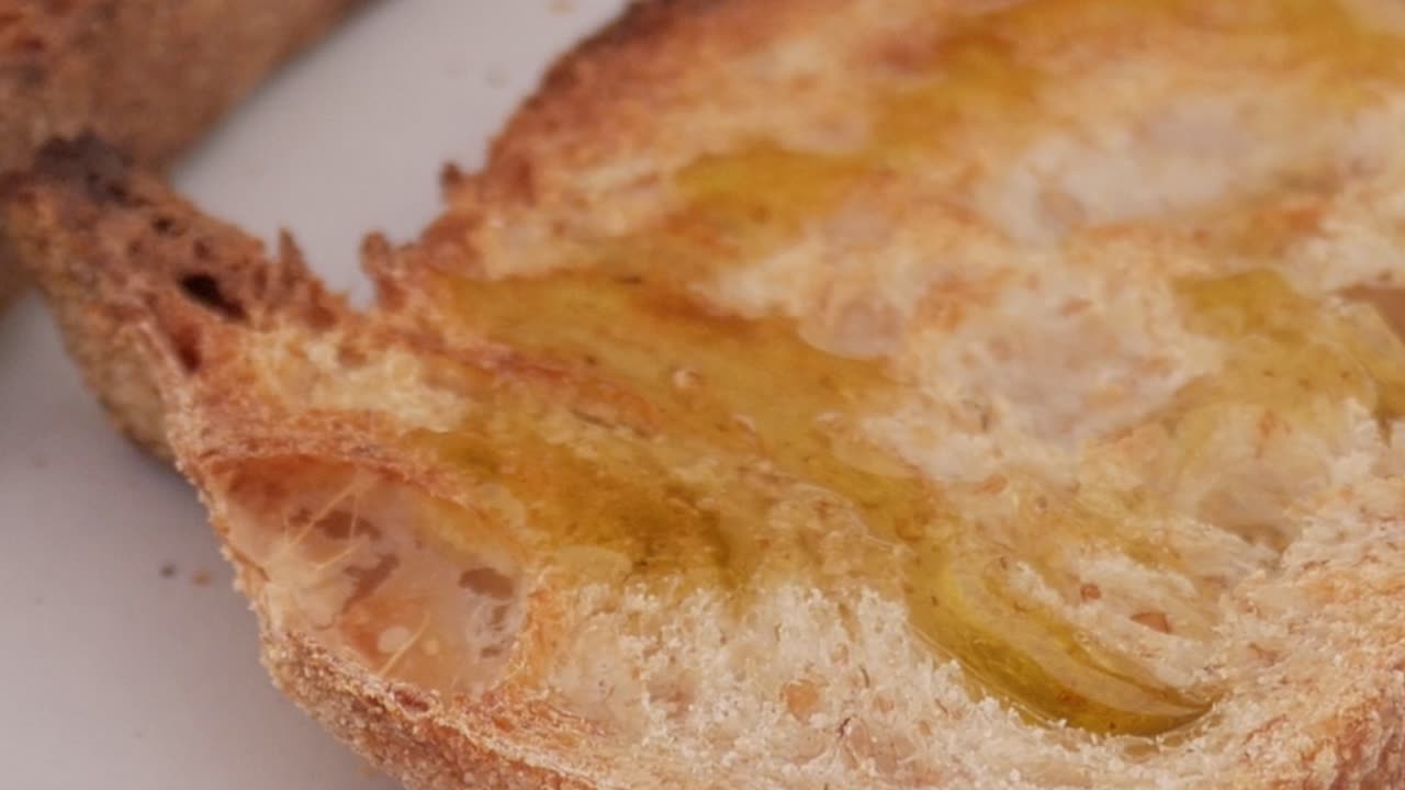 Crispy toast topped with a layer of olive oil, featuring the texture of fresh bread