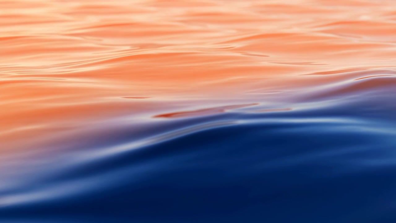 Nærbilde av en rolig havoverflate med lagdelt blå dønning, varme oransje refleksjoner, myke krusninger og glatte abstrakte teksturer, som skaper en rolig naturlig bakgrunn med moderne visuell balanse