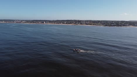 fishing boat navigating on atlantic ocean with uruguayan coastline in background