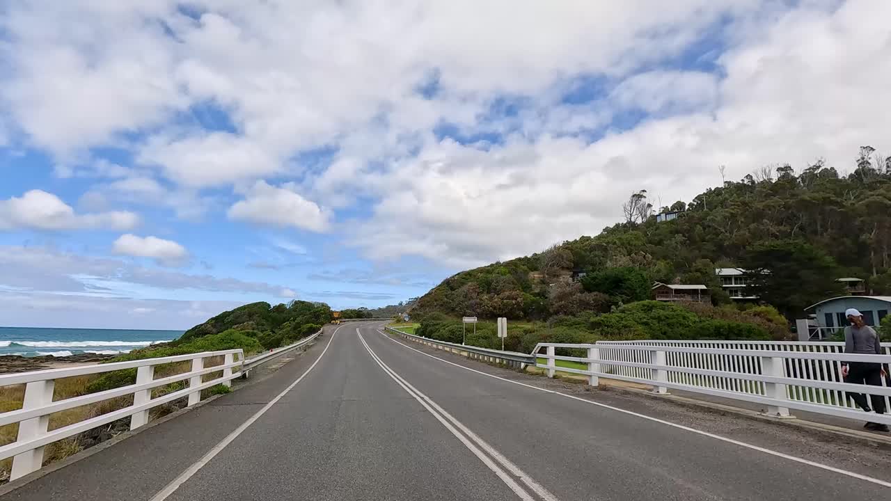 A 15-second drive along the Great Ocean Road, showcasing coastal views, lush greenery, and clear skies