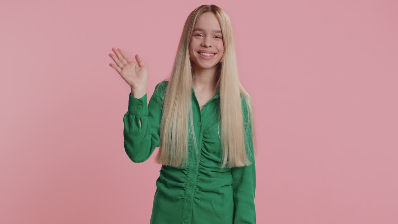 Young woman holding hand above eyes forehead peering into distance searching someone waving hello