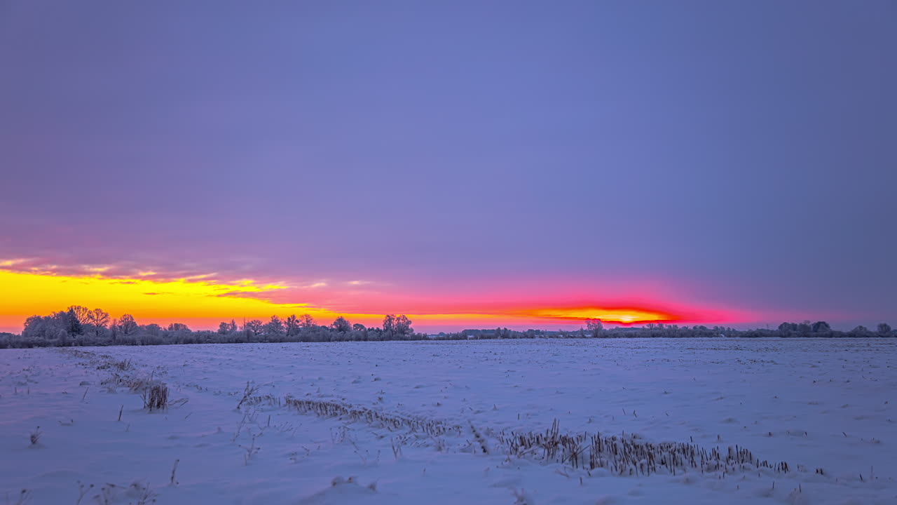 toma estática de nubes de tormenta y una puesta de sol sobre campos cubiertos de nieve