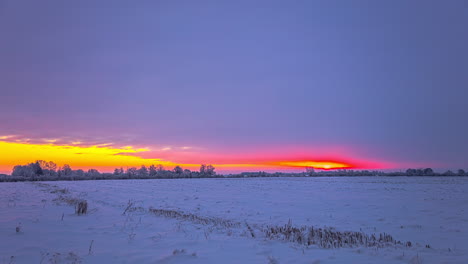 Static-shot-of-storm-clouds-and-a-sunset-over-fields-covered-in-snow