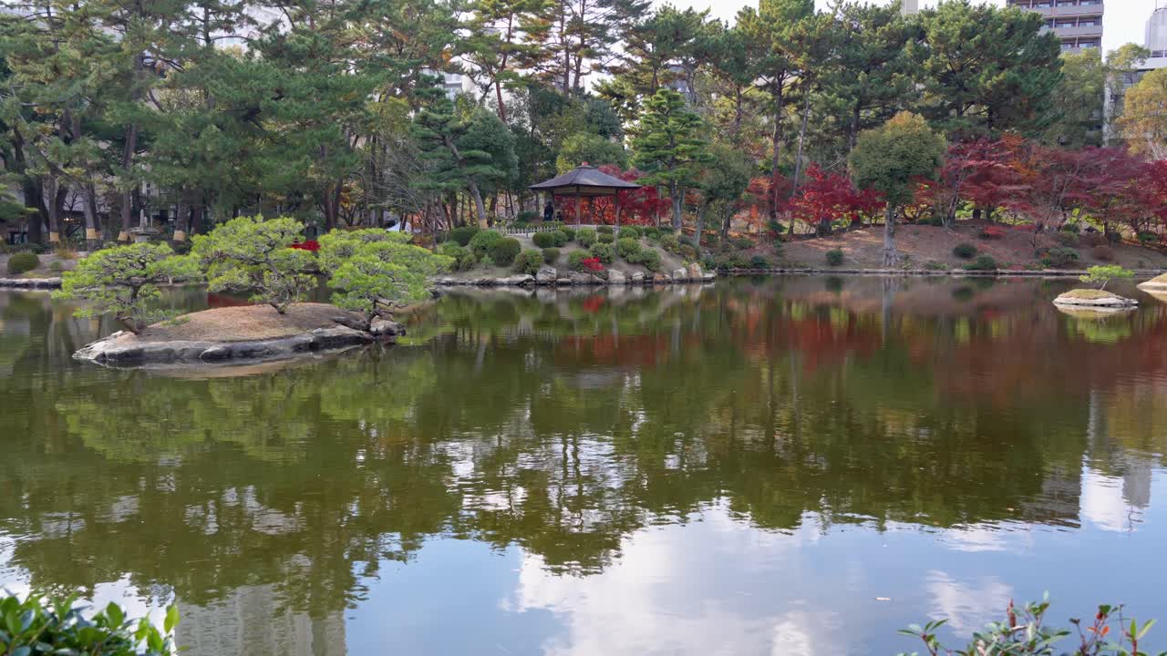 Wide shot showcasing the tranquil water, trees, and overlook of Japanese Garden in Japan