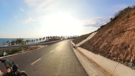 pov riding a motorcycle along the beautiful sunset coast of vietnam.