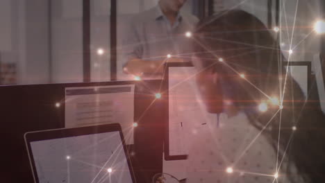 animation of glowing communication network over woman using computers in office