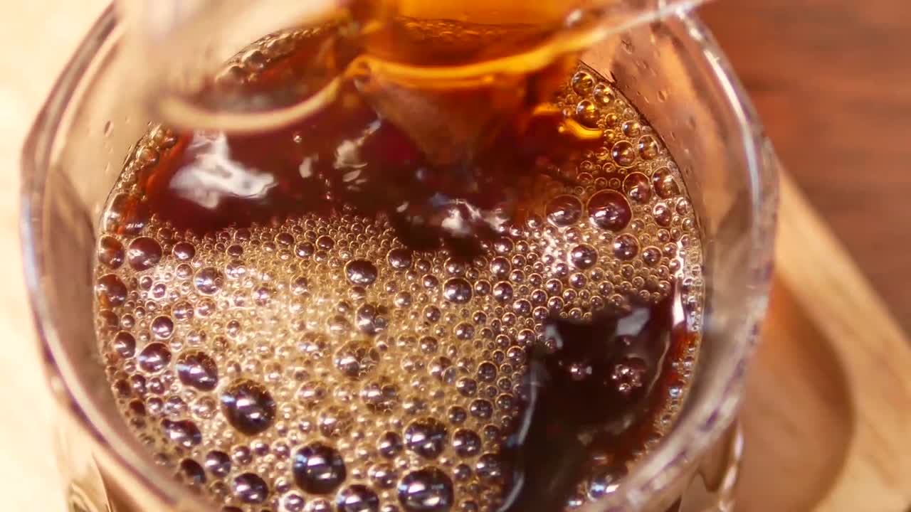 Ripresa ravvicinata di caffè versato dalla brocca nella tazza