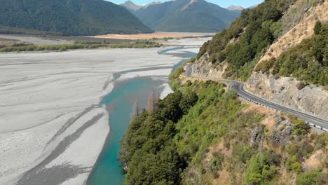 clip aerea di una strada vicino a un paesaggio pianeggiante in nuova zelanda, con la telecamera che avanza