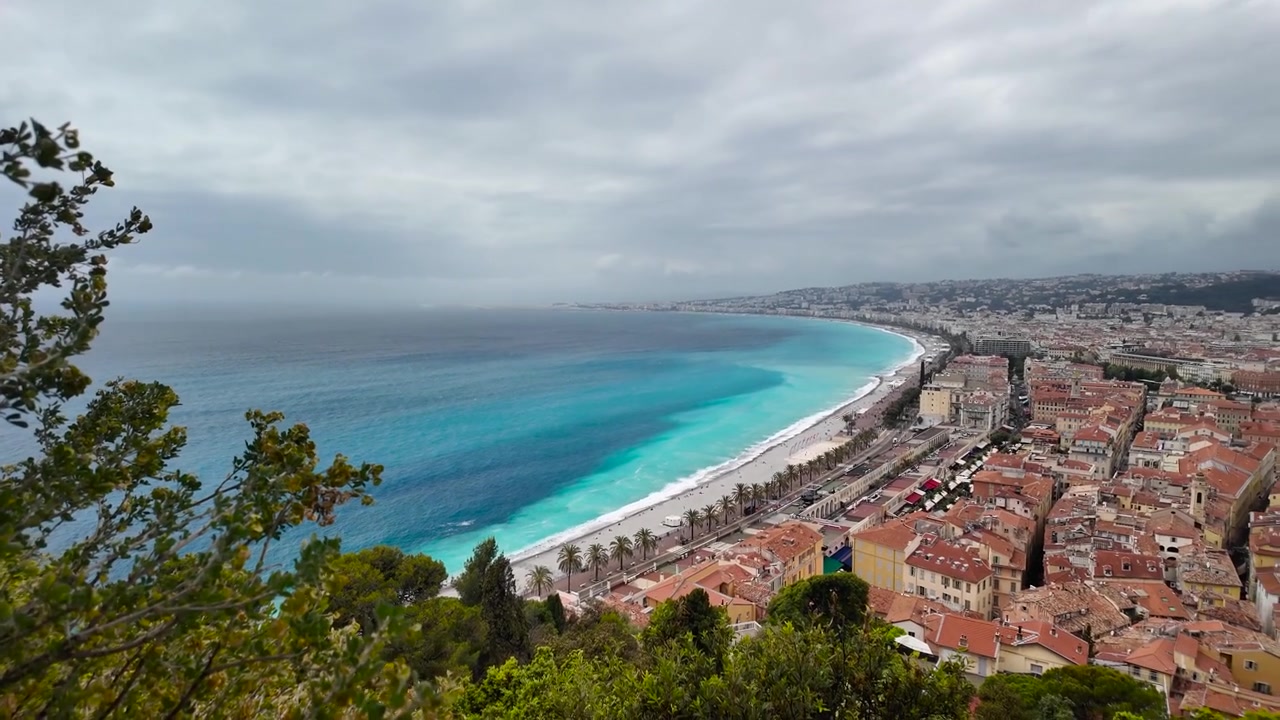 Ampia vista panoramica dalla Colline du Château a Nizza, che spazia dalle acque turchesi del Mediterraneo ai tetti in terracotta della città lungo l'iconica costa della Riviera