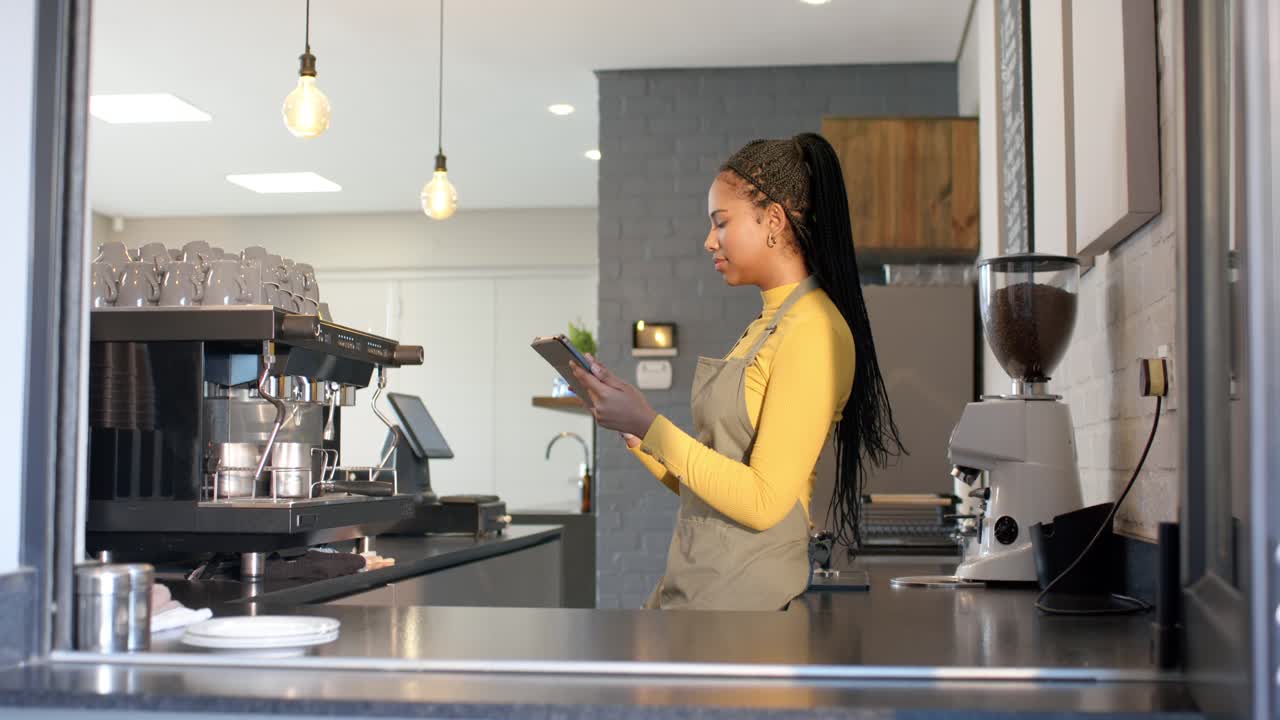 Una barista prende l’ordine a una cliente e scorre il menu su un tablet al bancone del bar, spazio per il testo