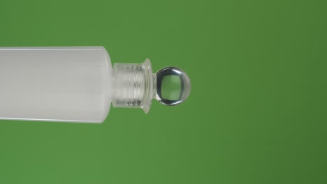 horizontal rotation of a face cream bottle on a green screen. close-up.