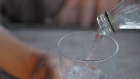 pouring water from bottle into glass