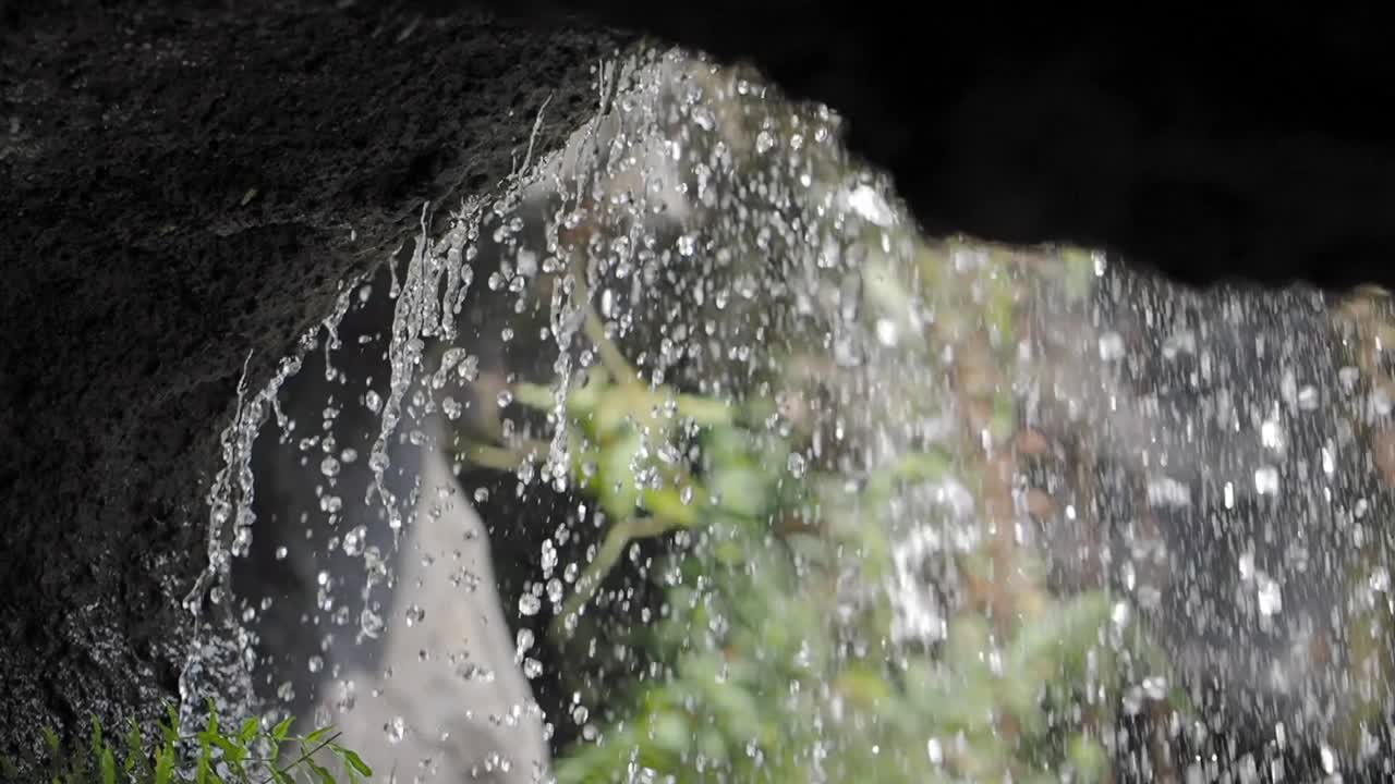 Close-up of Water Droplets Falling from a Rock