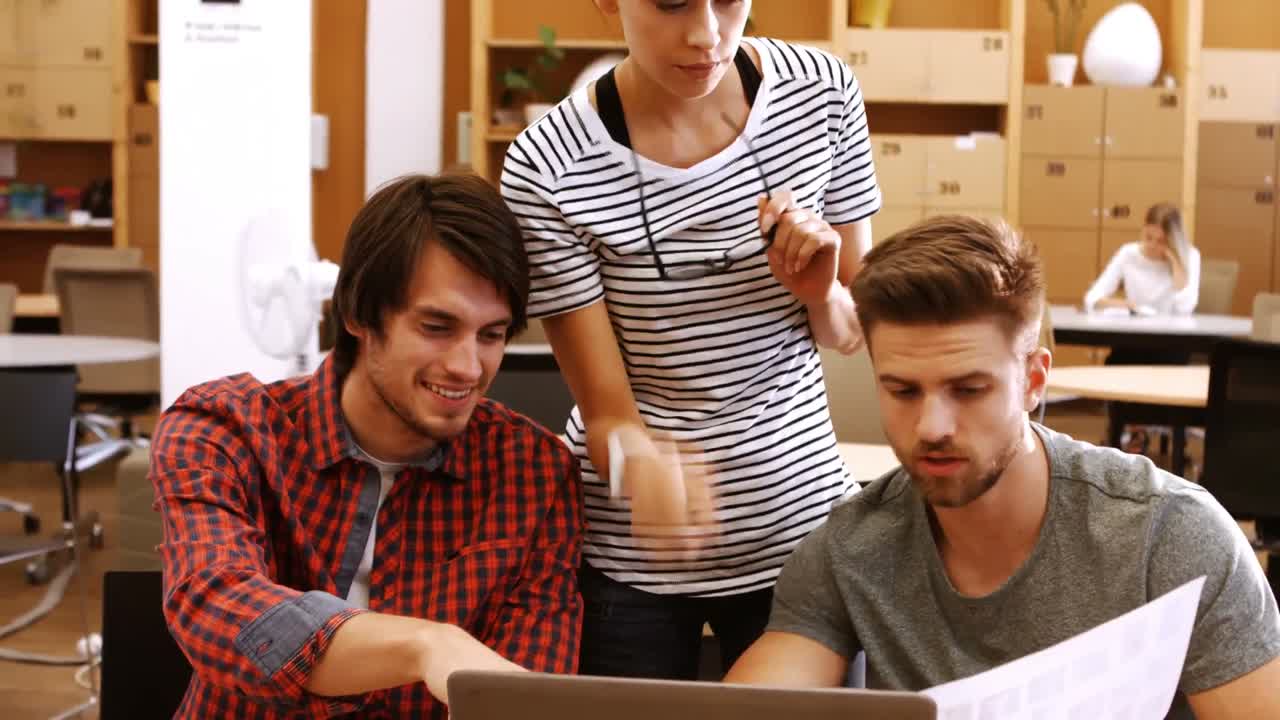 ejecutivos de negocios masculinos y femeninos discutiendo sobre computadora portátil en su escritorio