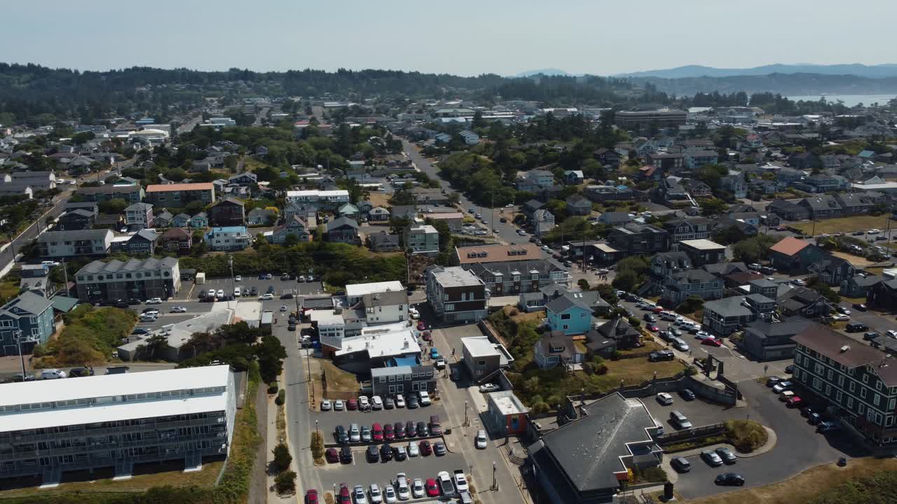 toma de un dron en sentido contrario a las agujas del reloj de la pequeña ciudad costera de newport, oregon, mientras los autos circulan por la ciudad