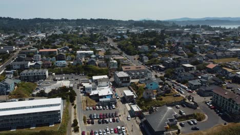 counterclockwise drone shot of the small coastal town of newport, oregon as cars drive around the town