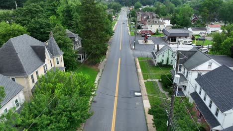 Victorian and classical houses with porch and Main Street with green trees. Aerial Birds Eye shot. Green front yards in suburb neighborhood of Pennsylvania, USA