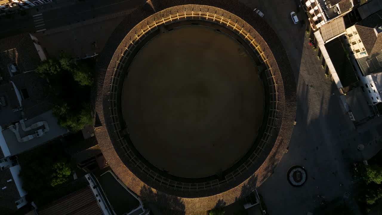 vista de arriba hacia abajo de la plaza de toros de la caballería real de ronda al atardecer en españa - disparo de drones