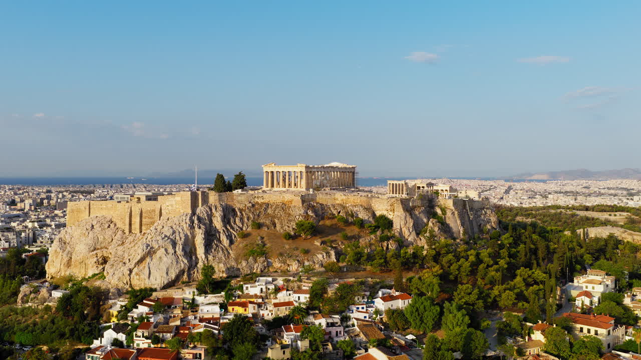 Panoramica aerea di Atene con l'Acropoli storica durante l'alba, con il Partenone illuminato dalla calda luce del sole mattutino