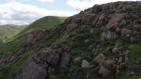 aerial view over a rocky mountain covered with grass