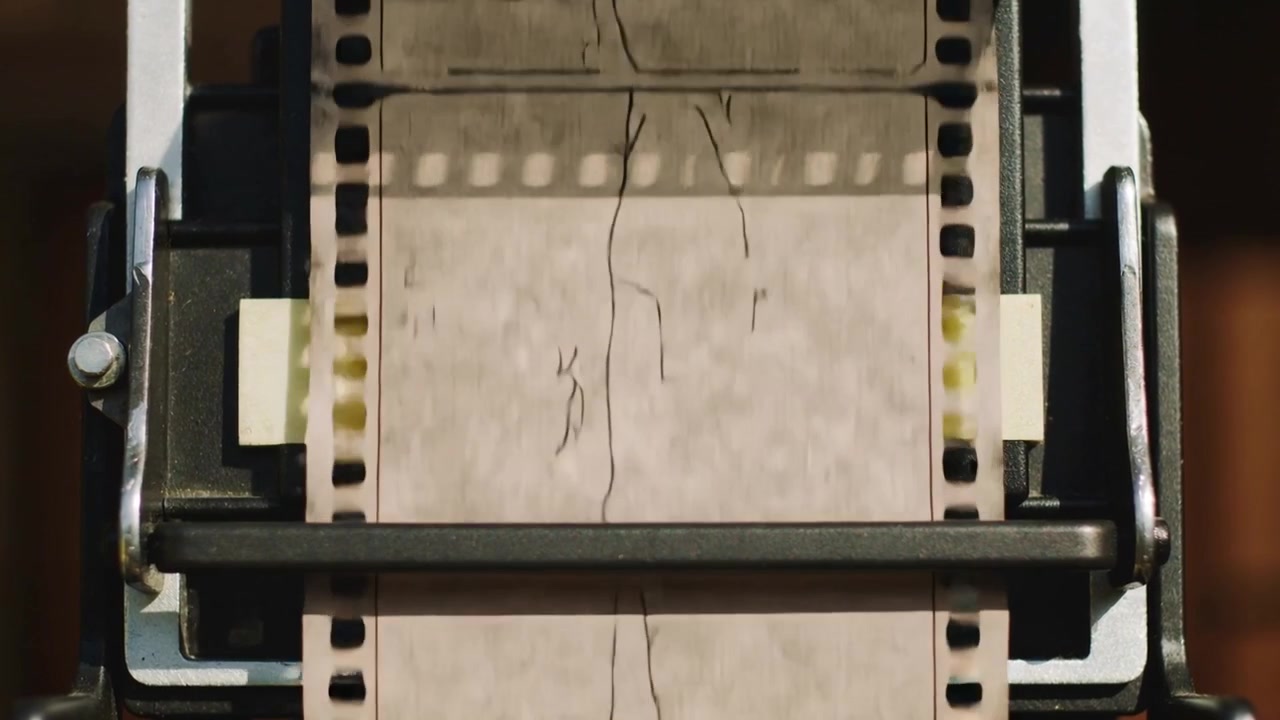 Motor startet Transport, zieht Film am Tor nach unten, um Bilder vorzuspulen, mit Haarrissen und Führungsstange.
